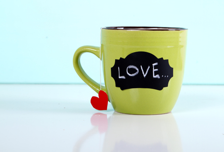 green mug tea bag heart on a blue background. with love inscriptionの写真素材
