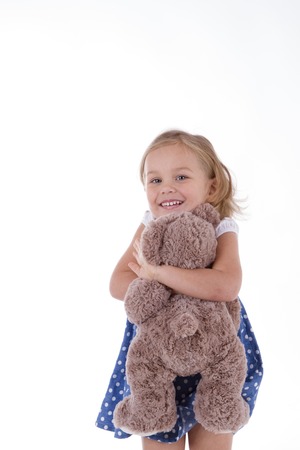 little girl with a teddy bear in the armsの写真素材