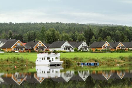 houses along the lake with gray metal roofs reflected in the water Scandinaviaの写真素材
