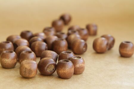 wooden beads separately in bulk arranged on a brown backgroundの写真素材