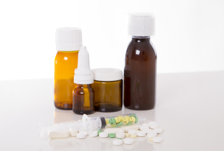 Subjects for treatment of illness. syringe with vitamins and pills in the foregroundの写真素材