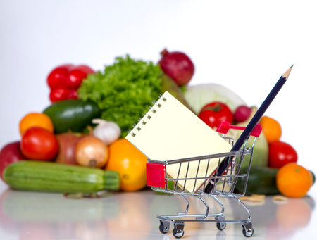 Plan your shopping list in a food shop - trolley with a notebook in the foreground. saving conceptの写真素材