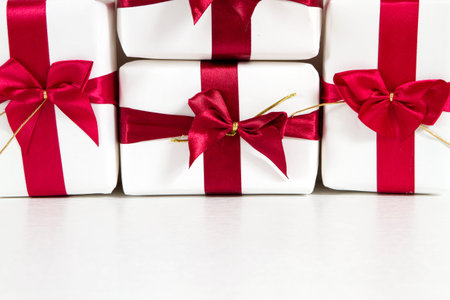 Background of the gifts of white paper with red ribbons with space for textの写真素材