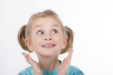 funny blond girl smiling hands to her face emotionの写真素材