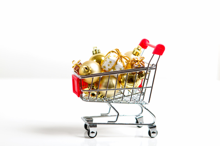 beautiful golden gifts with ribbon and Christmas balls in shopping cartの写真素材