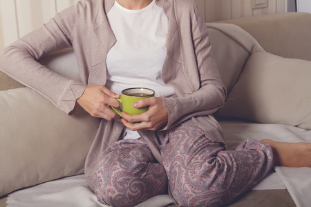 girl on the couch with a cupの写真素材