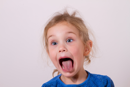 smiling little girl shows tongueの写真素材