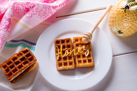Soft Belgian waffles with honey on vintage wooden background, top viewの写真素材