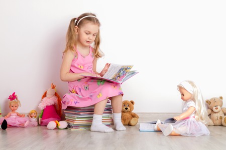 girl reads books to toysの写真素材
