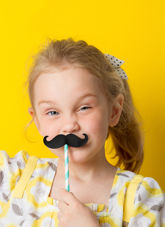 adorable girl has fun with a mustacheの写真素材