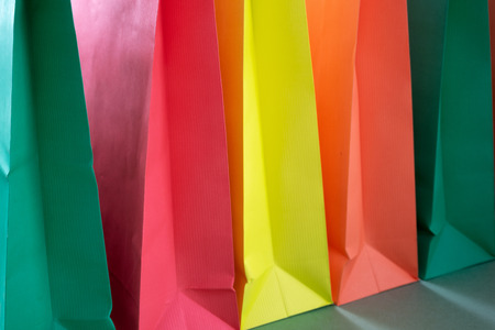 Paper shopping bags with handles on green background in row. Mockup for design.の写真素材