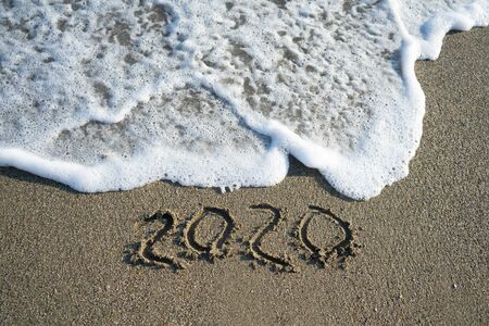 New year 2020 on sandy beach with wavesの写真素材