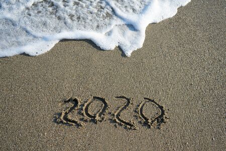 New year 2020 on sandy beach with wavesの写真素材