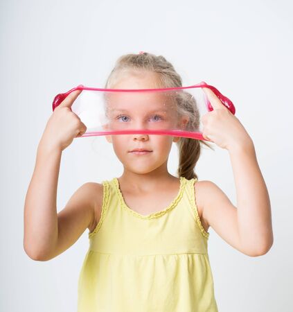 Happy joyful girl playing a red slimeの写真素材
