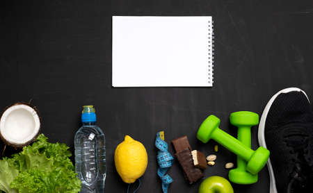 Composition with sports equipment and healthy snack on black background. Sports training backgroundの写真素材