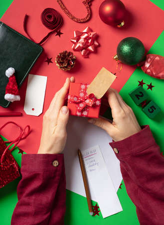holidays, people and celebration concept - close up of woman decorating christmas presentの写真素材