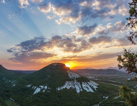 The sun rises from behind Mount Tepe-Kermen in the Crimean mountainsの写真素材
