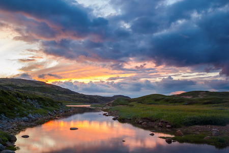 The bright sunset reflected in the river on the Kola Peninsulaの写真素材
