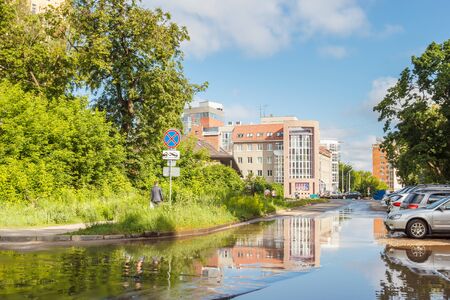 Reflection of a building in a wet summer road and carsのeditorial素材