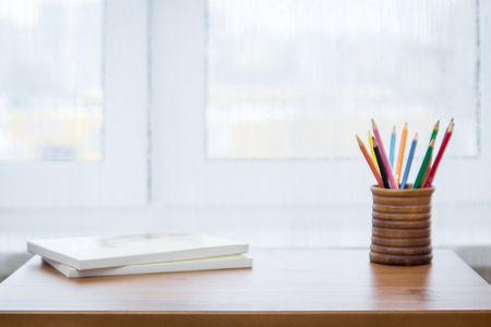 Background with colored pencils, notebooks and windowの写真素材