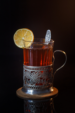 Tea with lemon in a glass with a cup holderの写真素材