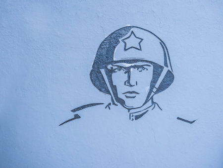 Image of a soldier at the war memorial, on a gray wall