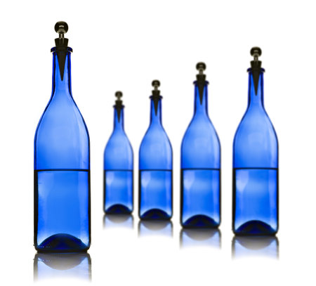 Five blue glass bottles with water on a white background