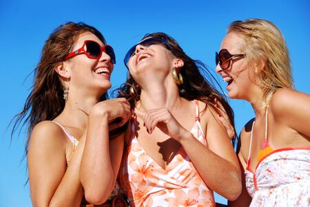 Three young woman having fun on the beach on a summer dayの写真素材