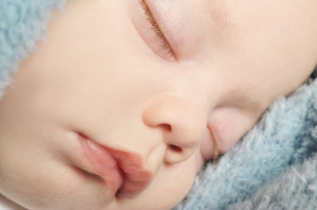 Adorable little baby sleeping peacefully on a blanketの写真素材