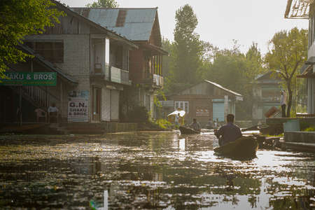 SRINAGAR, INDIA -21 JULY 2018: Floating convenience shop selling packed food items in the middle of Srinagar Lake's village, at sunset. Kashmir, Indiaのeditorial素材