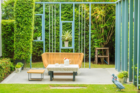 Tea set on a table in a small garden next to the house.の写真素材