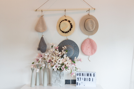 Beautiful female hat hanging on rope fabric. Flower in the vase Decorate the bedroom.のeditorial素材
