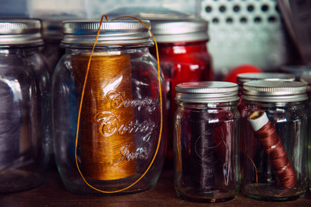 A color leather sewing thread in a bottles on wooden shelf side a metal wall important equipment for...