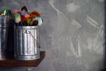Close up side view old many used leather craft paintbrush in a metal bucket with loft wall background and blank for copy space.の写真素材