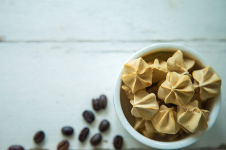 Top view close up Meringue coffee in a white ceramic bowl on white table with coffee beans blank for...