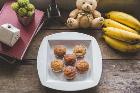 Top view Chocolate fudge cake with peppermint in a white plate on a white wooden table with a mobile phone and decoration and teddy bear.の写真素材