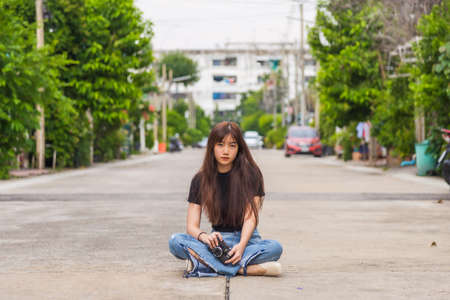 Close up portrait Smiling young Asian woman is sitting inside a white car and looking at the cameraの写真素材