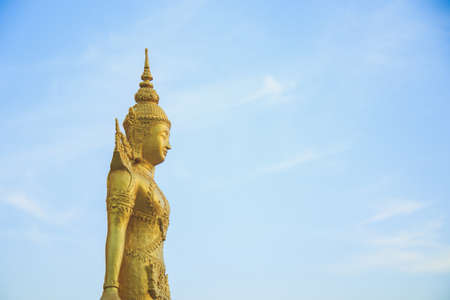 A golden Buddist angel statue against blue sky and blank for copy spaceの写真素材
