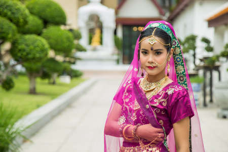 Portrait charming Asian woman wearing a traditional saree with a wall background.の写真素材