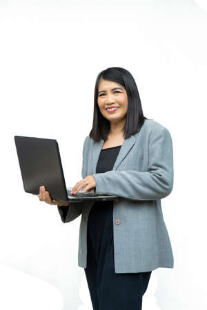 Portrait confident middle-aged Asian woman with her arms crossed wearing a gray jacket on white backgroundの写真素材
