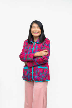 Portrait confident middle-aged Asian woman wearing red jacket points a thumb up, on a white background.の写真素材