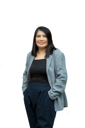 Portrait confident middle-aged Asian woman wearing gray jacket with hands in a pocket, on a white background.の写真素材