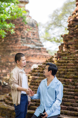 Couple lover Asian men hold hands and looking together while traveling in Asiaの写真素材