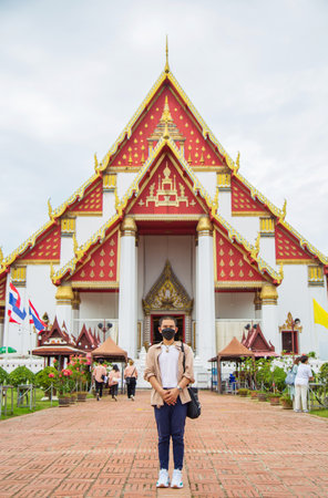 Portrait Asian man in casual wear wearing a face mask while traveling Buddhist temple in Asiaの写真素材