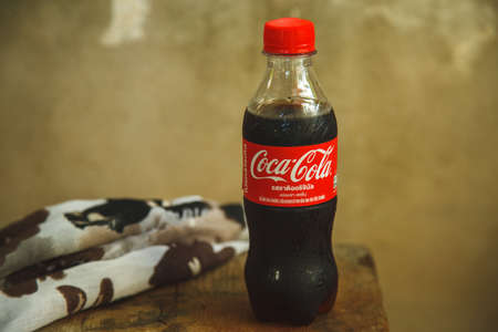 Bangkok, Thailand - 2022 March 28: Coca Cola or Coke on the wooden table  with concrete wall backgroundのeditorial素材