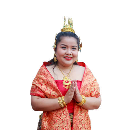 Smiling Asian woman in Thai dress with hands folded in salutation isolated on white background.の写真素材