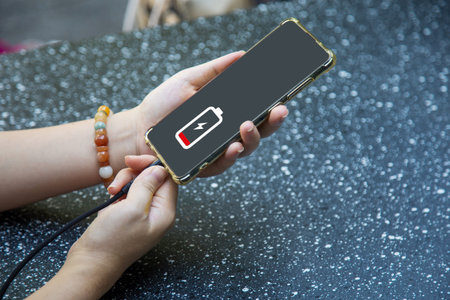 Close up a woman hands charging her mobile phone with charging icon