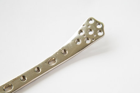An old locking plate with screws for treatment bone fractureon a white backgroundの写真素材