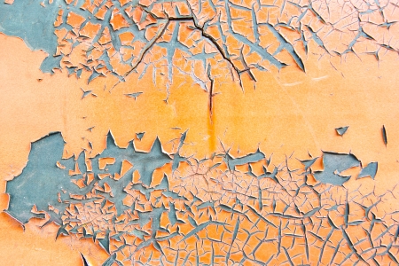 Orange paint flaking on grey metal surface textureの写真素材