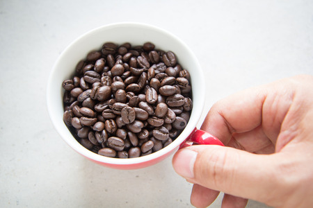 Man hand holding a red cup of roasted coffeeの写真素材